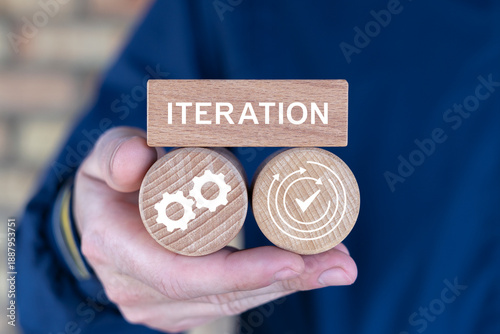 Fotografi Person holding wooden blocks with icons sees the text ITERATION