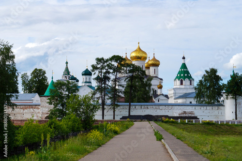 Billede på lærred Golden domes of Orthodox monastery behind green trees