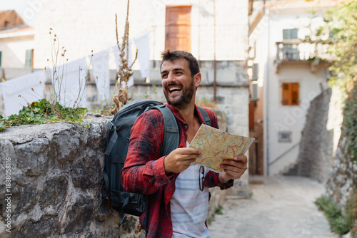 Young man with backpack and map exploring a historic old town