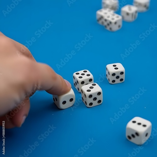 A person's hand manipulating three white game dice on a blue surface