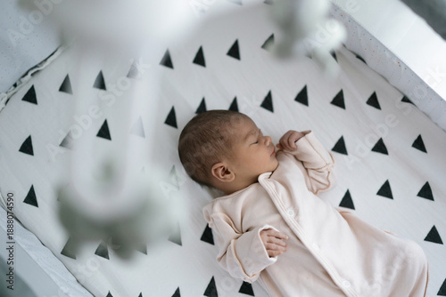 Canvastavla Newborn baby sleeping peacefully in a modern crib with geometric patterned beddi
