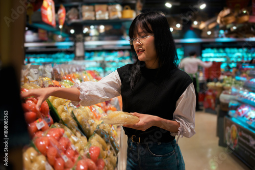 Foto Asian woman shopping for fresh produce in supermarket