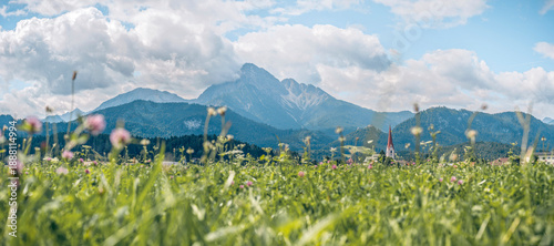 The Thaneller mountain, a distinctive landmark in the Ausserfern region, Tyrol, Austria. Lush meadows and the village of Reutte in the foreground under bright alpine sunlight.