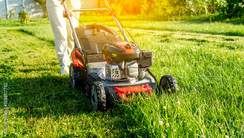 woman with lawn mower in garden plot