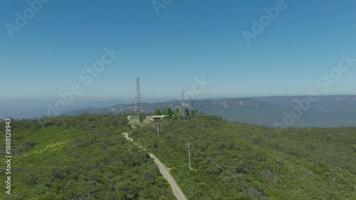 Drone aerial footage flying towards and over telecommunication towers on the ridgeline of the Jamison Valley in the Blue Mountains in New South Wales, Australia.