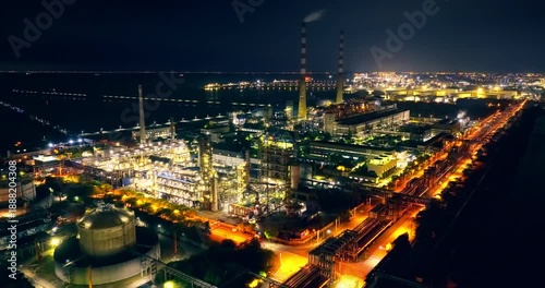 Wallpaper Mural Aerial view of a large industrial chemical plant and power station glowing with bright lights at night. Torontodigital.ca