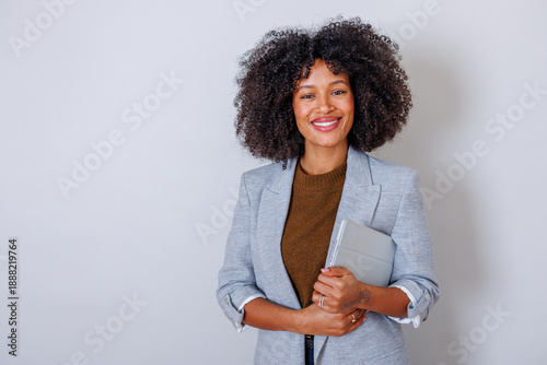 Schilderij op canvas Smiling professional black woman holding a tablet, exuding confidence, success,
