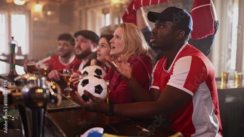 Disappointed soccer fans reacting to a lost match in a bar