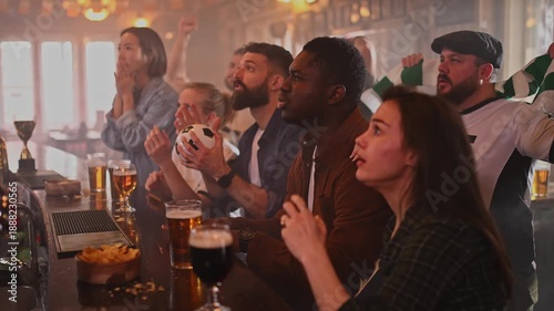 Diverse friends celebrating a goal together in a sports bar