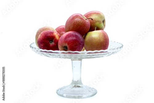 Ripe garden apples in a transparent fruit bowl. Isolated object for healthy eating, diet, harvest, and cozy kitchen interior themes.
