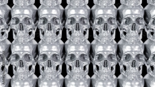 Front view of many silver chrome metal skulls arranged in rows. Metallic horror background.