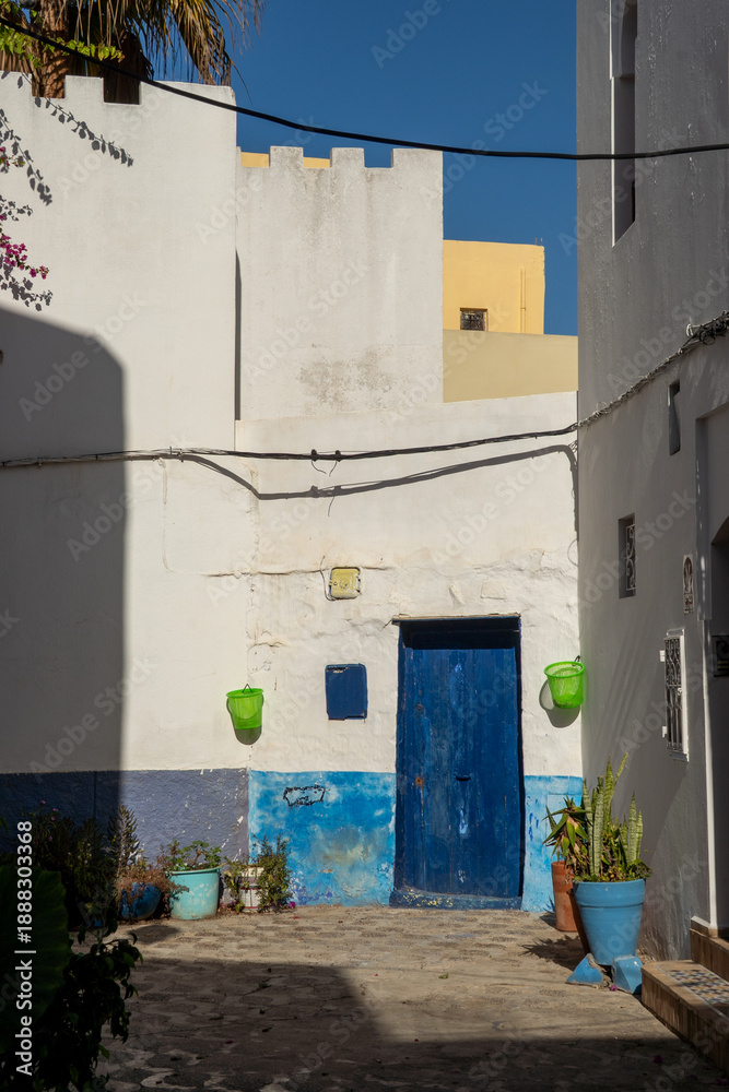 Fototapeta premium Blue door at the end of an alley in the medina in Asilah, Morocco