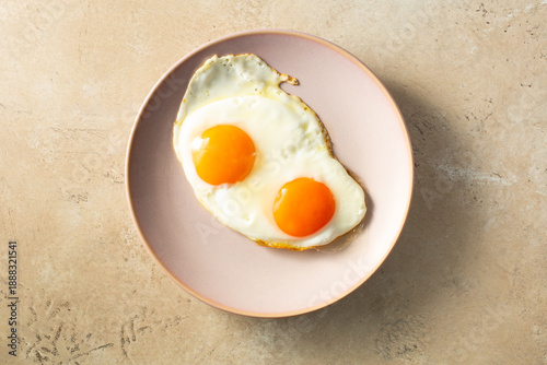 Fényképezés A top down view of a plate of fried orange yolk eggs.