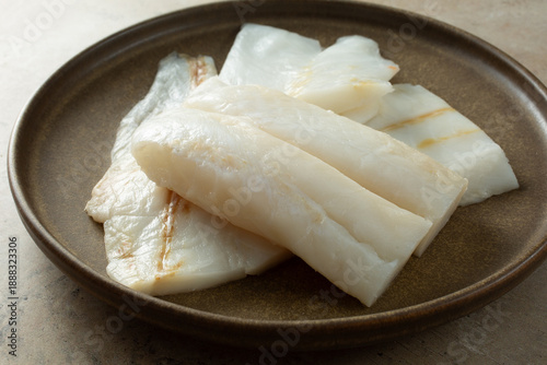 Foto A view of several raw orange roughy filets, on a plate.
