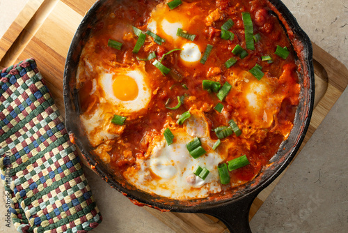A top down view of shakshuka, in a cast iron skillet.