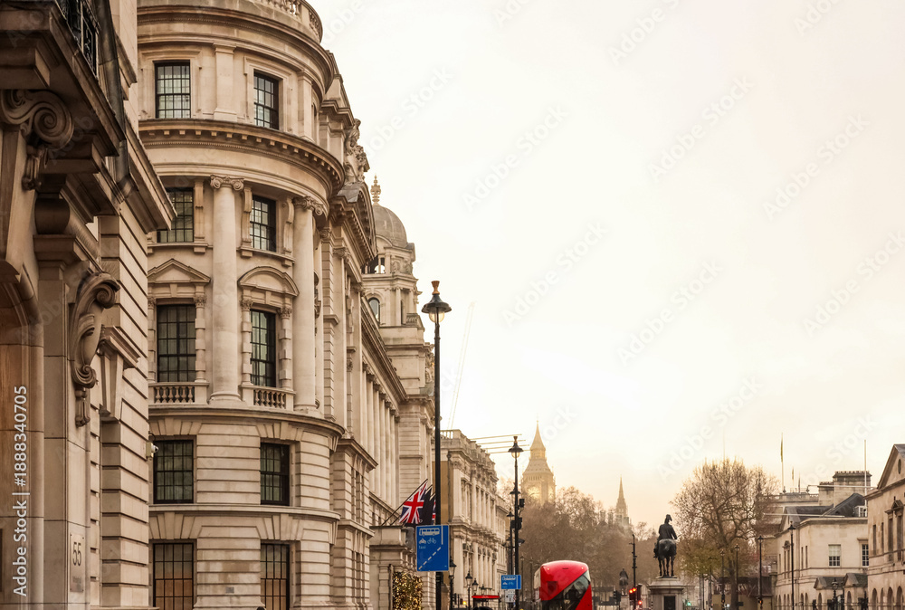 Obraz premium London cityscape featuring historic architecture, iconic red bus, and the distant Big Ben clock tower under a bright sky