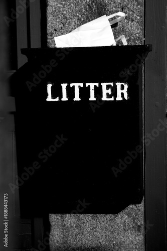 Litterbin with the word litter and paper bag in black and white.  Authentic vertical composition for graphical and environmental uses.