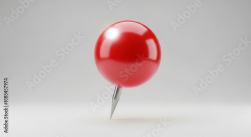 Red pushpin with shiny head standing upright on white surface and grey background