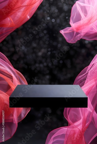 Elegant black podium on a dark background with flowing pink fabric, perfect for product display