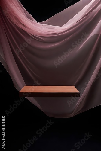 Elegant minimalist wooden podium display floating against flowing sheer pink fabric. Chic pedestal for product presentation on a dark background