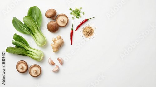 Fresh and aromatic Asian cooking ingredients like bok choy, shiitake mushrooms, ginger, chili peppers, garlic, and sesame seeds are artfully arranged.