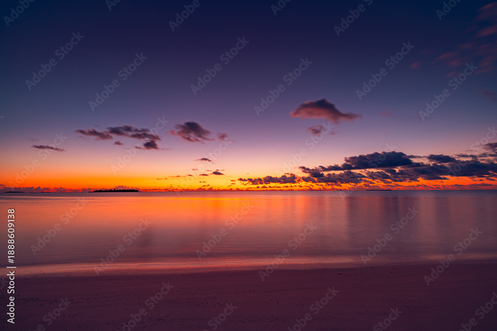 Fototapeta premium Peaceful majestic tropical ocean beach with sunrise and sunset sky, white fluffy clouds on horizon, inspirational meditation nature background, serene tropical landscape, relaxing scene