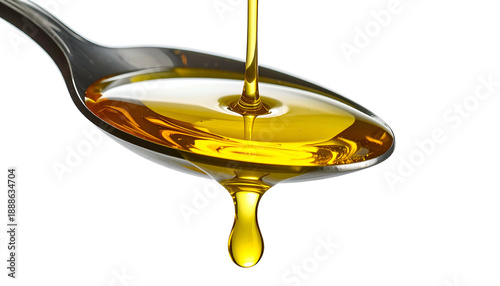 Close-up of golden liquid pouring from a spoon with a single drop falling against black