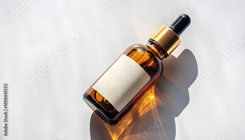 Amber glass dropper bottle with blank label on light background, modern cosmetic or essential oil packaging mockup, warm sunlight reflections, perfect for skincare, wellness and beauty branding design