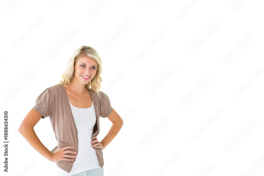 Fototapeta premium Adult female posing hands on hips, smiling, wearing layered clothing on white backdrop, copy space