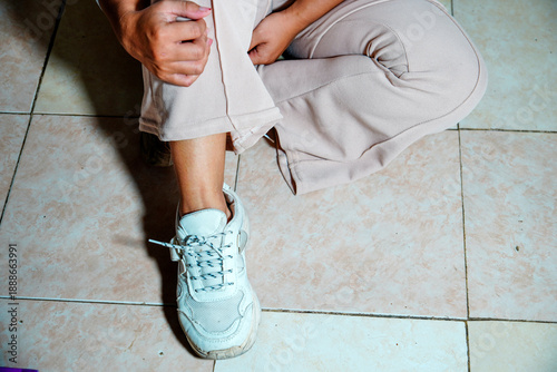 view of a woman's feet wearing white chunky sneakers with a thick sole design and patterned laces and a background for text space. close up of a woman's feet wearing sneakers and athletic shoes.