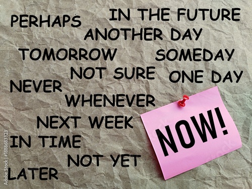 Fotografi Pink note paper written NOW with a gray background printed with many words conce