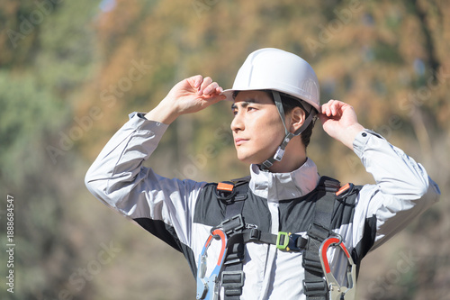 Photos 工事現場でヘルメットを被る日本人男性　撮影協力：多摩森林センター協同組合