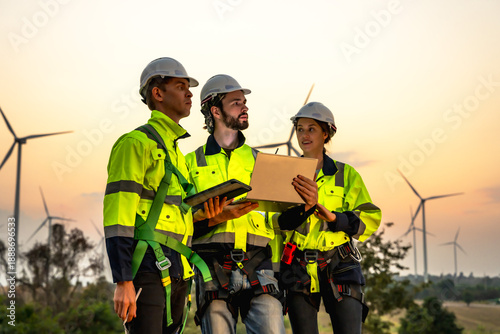 Male and female wind turbine engineers working together in rural wind turbine field