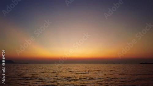 Beautiful sunset over calm sea water. Serene nature scene with dramatic sky gradient, 4k