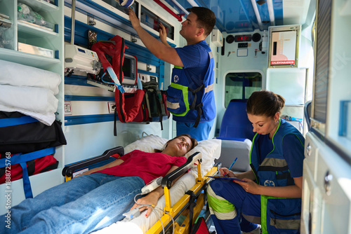 Foto Female patient receiving emergency care from paramedics in ambulance