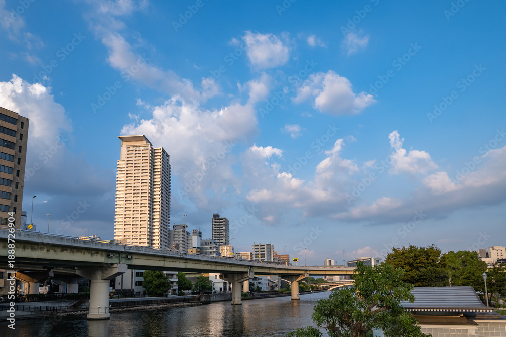 Fototapeta premium 夕焼け雲と川をまたぐ高速道路とタワーマンション