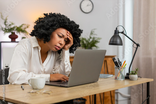 Canvas Print African American businesswoman at home office frowns at laptop upset by game defeat fail, rejection email