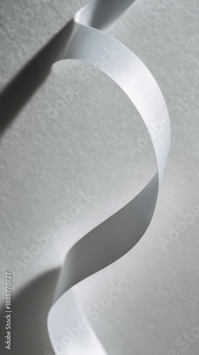 drape. A white ribbon curving downward against a minimalist gray background. wellbeing guides, coaching materials, designed for mental health education and mindfulness programs, clarifies learning.
