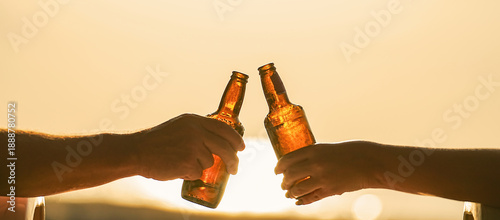 Tableau sur toile Two vacationing friends or a married couple on vacation clink bottles of cold beer in their hands