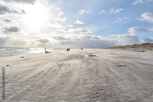 Dramatic stormy sky over an empty sandy beach with waves and dark clouds. Moody seascape landscape with strong wind, cold atmosphere and vast open space. Minimalist coastal scenery, solitude and natur