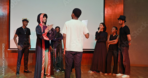 Foto African young adult gen z male man hold scripts paper read play story lines scene standing indoor stage hall