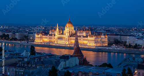 Fotografía Budapest Parliament Building Illuminated at Night: The grand Budapest Parliament Building shimmers with golden light against the backdrop of a deep blue evening sky