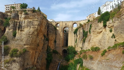 Obraz na płótnie Ronda Bridge and Cliff: The iconic Puente Nuevo bridge, a testament to architectural marvel, spans a breathtaking gorge in Ronda, Spain, surrounded by rugged cliffs and lush vegetation
