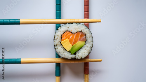 Creative sushi roll presentation with chopsticks on books background
