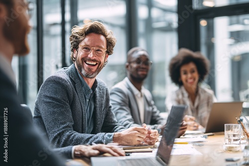 Diverse business team laughing together in modern office during meeting