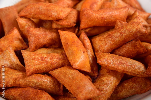 Top view of a plate of corn cookies with tomato and chilli flavored filling on a white background (cuscinetti croccanti)