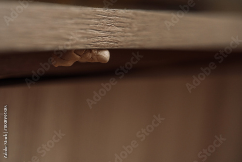 Billede på lærred Chewed chewing gum stuck under wooden table, dirty habit and hygiene concept