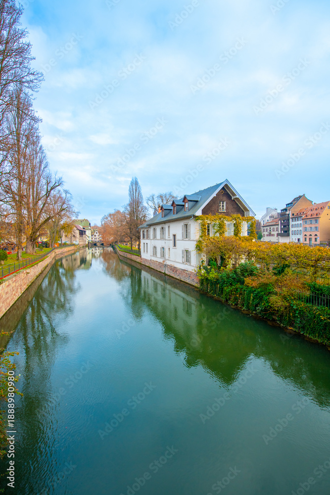 Fototapeta premium Strasbourg, France - December 5, 2025: Beautiful travel landscape with half-timbered houses on the banks of the river ill and decorated flowers in Strasbourg. France quarter in Strasbourg.