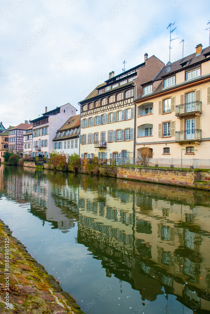 Fototapeta premium Strasbourg, France - December 5, 2025: Beautiful travel landscape with half-timbered houses on the banks of the river ill and decorated flowers in Strasbourg. France quarter in Strasbourg.