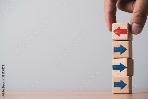 Tableau sur toile Hand change direction of wooden red arrow blocks for showing disruption change for business transformation and technology innovation shift concept